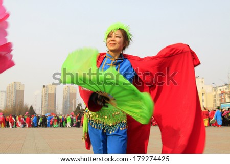 LUANNAN COUNTY - FEBRUARY 13: Young woman wearing colorful clothes, performing yangko dance in the street, during the Chinese Lunar New Year, February 13, 2014, Luannan County, Hebei Province, China.