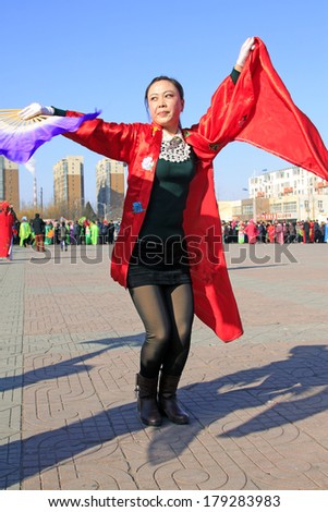 LUANNAN COUNTY - FEBRUARY 10: Young lady wearing colorful clothes, performing yangko dance in the street, during the Chinese Lunar New Year, February 10, 2014, Luannan County, Hebei Province, China.