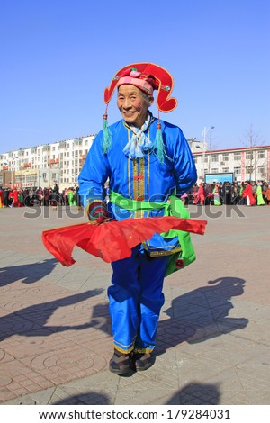 LUANNAN COUNTY - FEBRUARY 10:  Old woman wearing colorful clothes, performing yangko dance in the street, during the Chinese Lunar New Year, February 10, 2014, Luannan County, Hebei Province, China.