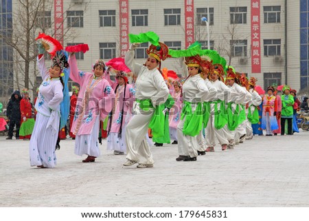 LUANNAN COUNTY - FEBRUARY 8: People wearing colorful clothes, performing yangko dance in the street, during the Chinese Lunar New Year, February 8, 2014, Luannan County, Hebei Province, China.