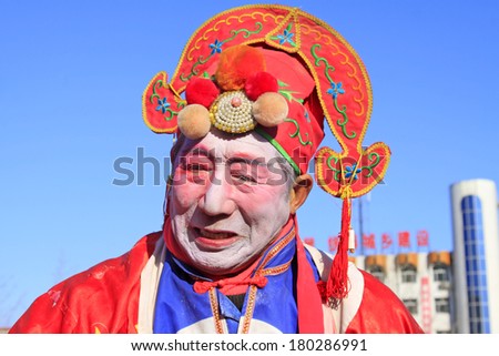 LUANNAN COUNTY - FEBRUARY 9: Old man wearing colorful clothes, performing yangko dance in the street, during the Chinese Lunar New Year, February 9, 2014, Luannan County, Hebei Province, China.
