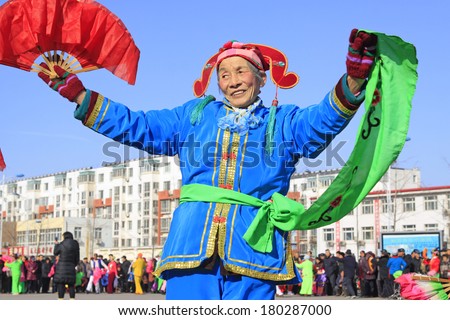 LUANNAN COUNTY - FEBRUARY 10:  Old woman wearing colorful clothes, performing yangko dance in the street, during the Chinese Lunar New Year, February 10, 2014, Luannan County, Hebei Province, China.