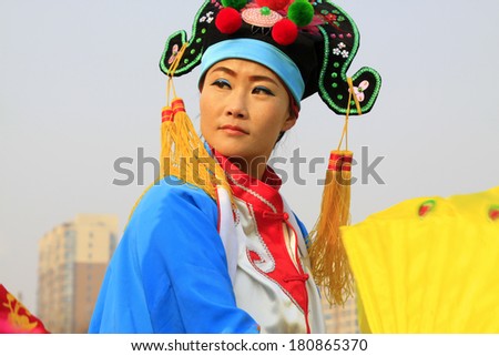 LUANNAN COUNTY - FEBRUARY 12: Young woman wearing colorful clothes, performing yangko dance in the street, during the Chinese Lunar New Year, February 12, 2014, Luannan County, Hebei Province, China.
