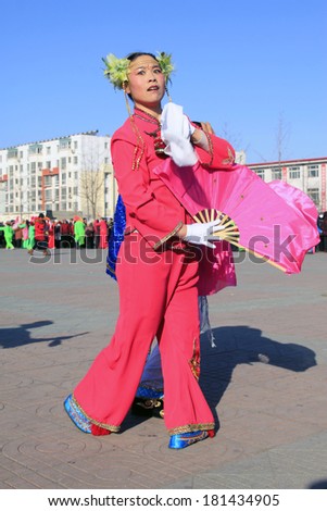 LUANNAN COUNTY - FEBRUARY 10: Lady wearing colorful clothes, performing yangko dance in the street, during the Chinese Lunar New Year, February 10, 2014, Luannan County, Hebei Province, China.