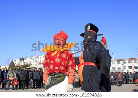 LUANNAN COUNTY - FEBRUARY 9: Monkey King and Zhubajie wearing colorful clothes, performing yangko dance in the street, February 9, 2014, Luannan County, Hebei Province, China.