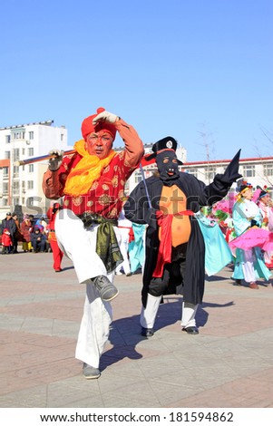 LUANNAN COUNTY - FEBRUARY 9: Monkey King and Zhubajie wearing colorful clothes, performing yangko dance in the street, February 9, 2014, Luannan County, Hebei Province, China.
