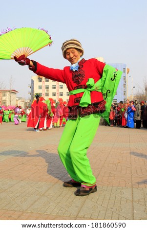 LUANNAN COUNTY - FEBRUARY 12: Woman wearing colorful clothes, performing yangko dance in the street, during the Chinese Lunar New Year, February 12, 2014, Luannan County, Hebei Province, China.