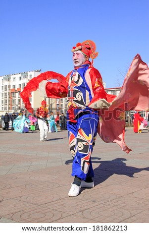 LUANNAN COUNTY - FEBRUARY 9: Old man wearing colorful clothes, performing yangko dance in the street, during the Chinese Lunar New Year, February 9, 2014, Luannan County, Hebei Province, China.