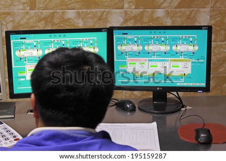 LUANNAN - MAY 4: Technicians were monitoring mechanical equipment running status in control room, on May 4, 2014, Luannan county, hebei province, China.