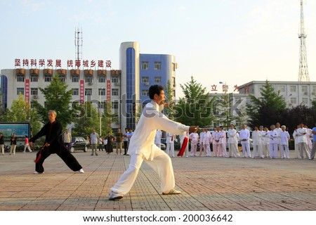 LUANNAN COUNTY - JUNE 14: An old man was performing Taiji sword on the gym in the square, on june 14, 2014, LuanNan county, hebei province, China