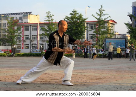 LUANNAN COUNTY - JUNE 14: A man was performing Tai chi chuan on the gym in the square, on june 14, 2014, LuanNan county, hebei province, China