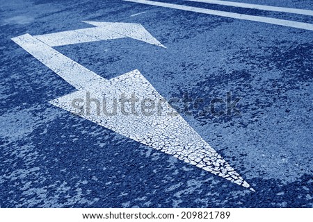 white arrow symbol on asphalt road, closeup of photo