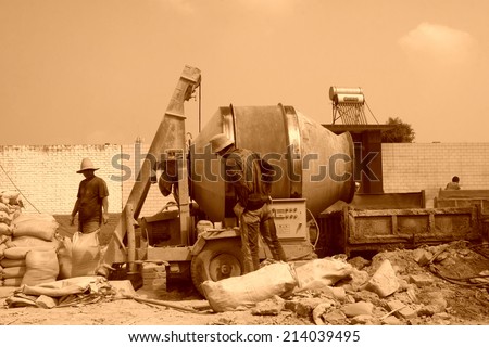 LUANNAN COUNTY - AUGUST 15: bags of cement and concrete mixer in the construction site, on august 15, 2014, Luannan County, Hebei Province, China