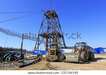 LUANNAN COUNTY - OCTOBER 13: Drilling derrick and heavy duty truck in MaCheng iron mine, on october 13, 2014, Luannan County, Hebei Province, China