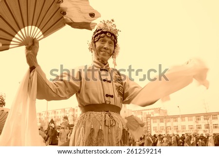 LUANNAN COUNTY - FEBRUARY 15: Old man wearing colorful clothes, performing yangko dance in the street, during the Chinese Lunar New Year, February 15, 2014, Luannan County, Hebei Province, China.
