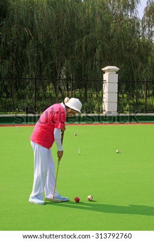 LUANNAN COUNTY - AUGUST 29: An elderly woman exercise China gate ball, on August 29, 2015, Luannan County, Hebei Province, China.