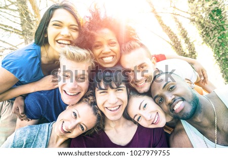 Best friends taking selfie at picnic with back lighting - Happy youth friendship concept against racism with young people having fun together - Vintage desaturated filter with sunshine halo flare