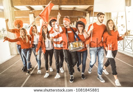 Football supporter fans friends cheering and walking to soccer cup match at intenational stadium - Young people group with red and white t-shirts having excited fun on sport world championship concept