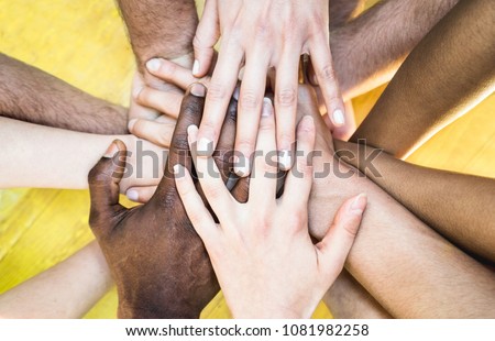 Top view of multiracial stacking hands - International friendship concept with multiethnic people representing peace and unity against racism - Multi racial love and integration between diversity