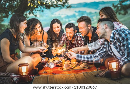 Happy friends having fun with fire sparkles - Young people millennials camping at picnic after sunset - Young people enjoying wine at summer barbecue party - Youth friendship concept on night mood