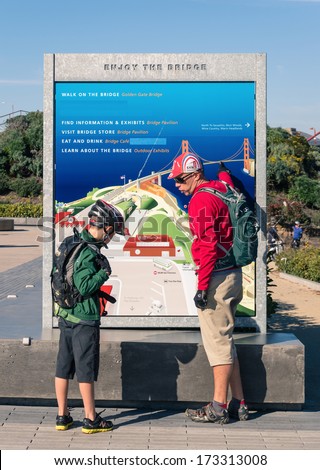 SAN FRANCISCO - DECEMBER 14, 2013: sporty father and son studying the crossing of the Golden Gate Bridge. The main walkway on the eastern side is open both for pedestrians and bicycles.
