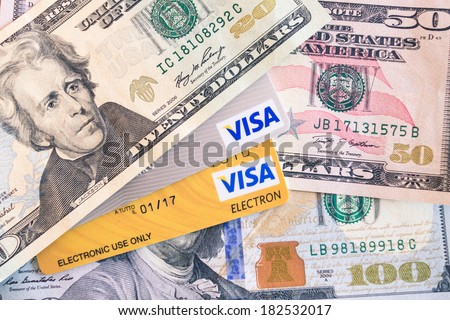 BANGKOK, THAILAND - FEBRUARY 21, 2014: Visa and Visa Electron credit cards and dollar bills. Visa Inc. is an american financial services corporation based in Foster City, California, United States.