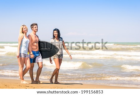 Group of young happy people on vacations at the beach holding a surf table - Best friends with girlfriends having fun in the summer with surfboard boogieboard during travel holidays