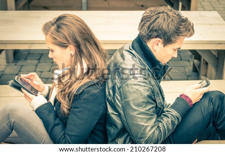 Couple in a modern common phase of mutual disinterest and sadness - Concept of apathy connected to the alienation fron new technologies - End of a love story