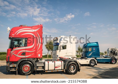 RIMINI, ITALY - SEPTEMBER 7, 2014: Scania semi trucks parked along the beach promenade in Rivazzurra, Adriatic Coast. Scania Aktiebolag is a major Swedish industry manufacturer of commercial vehicles.