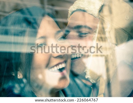 Young happy couple in love at the beginning of a Love Story - Fashion man whispers a soft kiss in the ear of the loved young woman
