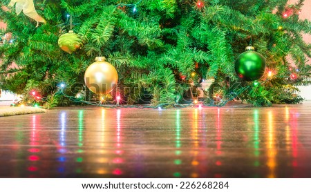 Detail of Christmas tree decorations with lights reflections on the floor - Cropped composition for holidays background