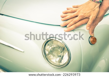 Couple of lovers holding hands on a vintage classic car body - Concept of love and connection with vintage lifestyle and travel trasportation - Retro nostalgic filtered look