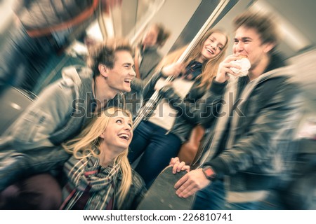 Group of young hipster friends having fun interaction and talking in subway train - Vintage filtered look with radial defocusing - Concept of youth and friendship