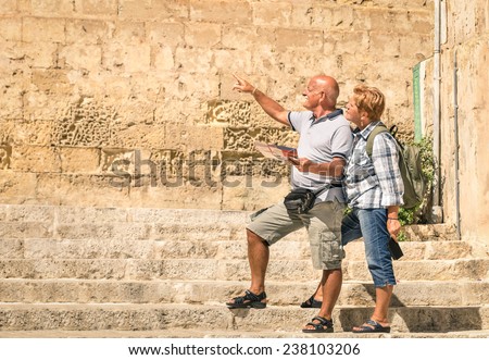 Happy senior couple exploring old town of la Valletta with city map - Concept of active elderly and travel lifestyle without age limitation - Trip to european mediterranean wonders