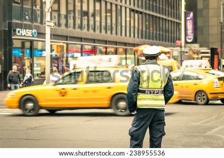 NEW YORK CITY - 22 DECEMBER, 2013: unidentified NYPD officer on the streets of Manhattan with yellow taxi cabs. Established in 1845, NYPD is the largest municipal police force in the United States