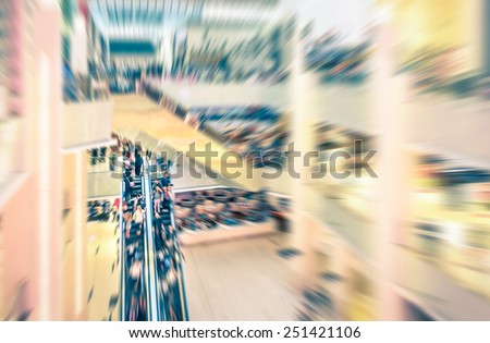 Shopping mall on radial zoom defocused editing - Vintage desaturated filtered look of unrecognizable people moving on escalators with motion blur - Concept of  social gathering and globalization