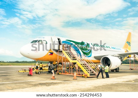 PUERTO PRINCESA, PHILIPPINES - 15 FEBRUARY, 2015: staff people moving around Cebu Pacific aircraft after landing at Puerto Princesa International Airport. Main hub is at Ninoy Aquino Airport in Manila