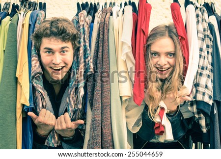 Young hipster couple having at clothing market - Best friends sharing free time and shopping during spring cheap sales - Lovers enjoying everyday life moments on a soft focus and vintage filtered look