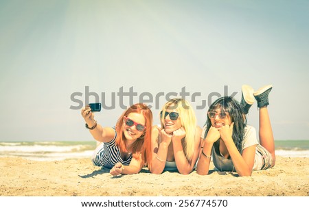 Happy girlfriends taking a selfie at beach - Concept of friendship and fun in the summer with new trends and technology - Best friends enjoying moments with modern smartphone - Vintage filtered look