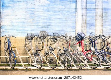Multicolored vintage bicycles in metal rack in Tokyo city - Urban ecological transportation concept with retro bikes - Ryogoku residential district in the japanese world famous capital - Logos removed