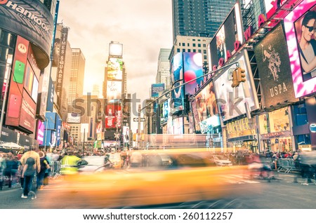 NEW YORK - DECEMBER 22, 2014: blurred yellow taxi cab and rush hour congestion at Times Square in Manhattan, one of the most visited tourist attractions in the world. Warm vintage filtered editing.