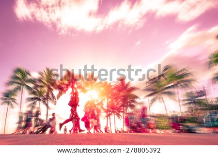 Man running through the crowd at sunset on Kalakawa Ave - Front walk promenade of Waikiki Beach in Honolulu Hawaii - Freedom and sport concept - Radial zoom defocusing with vintage marsala color tone
