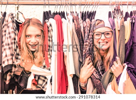 Young hipster women at clothes flea market - Best friends sharing fun time shopping in the city - Happy girlfriends enjoying happy life moments - Soft focus on warm vintage pink marsala filtered look