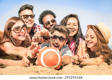 Group of multiracial happy friends having fun at beach games - International concept of summer joy and multi cultural friendship together - Warm sunny afternoon color tones with shallow depth of field