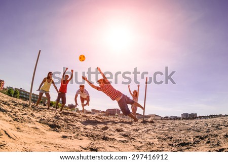Multiracial friends playing soccer at beach - Concept of multi cultural friendship having fun with summer games - Backlight marsala filter with late afternoon sunshine halo and fisheye lens distortion