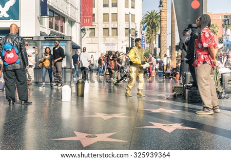 LOS ANGELES - MARCH 21, 2015: street artists and everyday multiracial people around the world famous Walk Of Fame in late afternoon on Hollywood Boulevard in LA California - United States of America