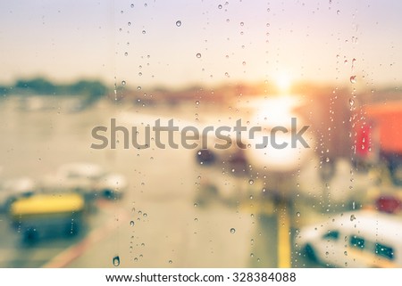 Abstract defocused bokeh of airplane at airport gate with sun coming out after the rain - Modern travel concept and wander lifestyle at sunset - Focus on raindrops with warm vintage filtered look