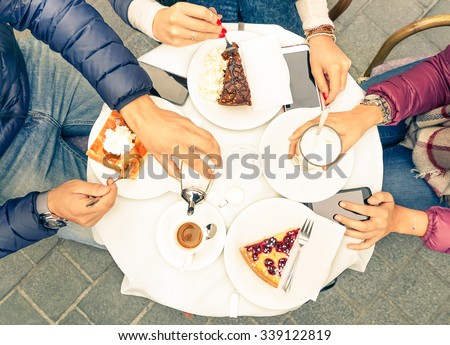 Friends group with cakes coffee and milk at bar restaurant - Close up of people hands with smartphones with upper point of view - Technology concept with addicted men and women - Warm vintage filter