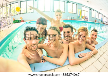 Best friends taking selfie in swimming pool - Happy friendship concept with young people having fun together - Warm vintage filter with soft focus on faces due to natural lights and backlight contrast