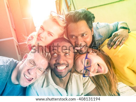 Best friends taking selfie outdoors with back lighting - Happy friendship concept with young people having fun together - Peace and love against racism - Multicolored filter and sunshine halo flare